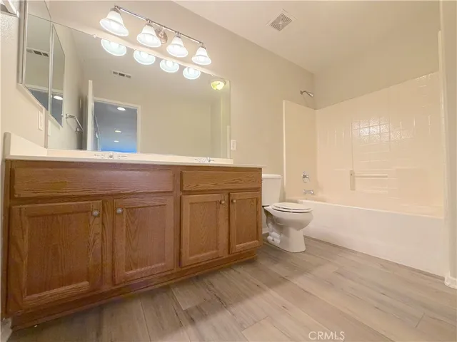 a spacious bedroom with a bed and a chandelier