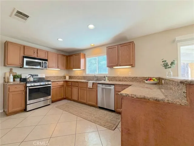 a kitchen with stainless steel appliances granite countertop a stove sink and microwave