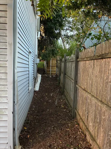 a view of a pathway of a house with wooden fence