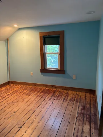 a view of a room with wooden floor and window