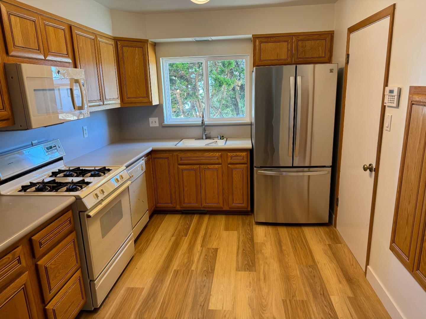155 Shell Street Pacifica, CA 94044 - Photo 2 of 10 a kitchen with wooden floors stainless steel appliances a stove a sink and a window
