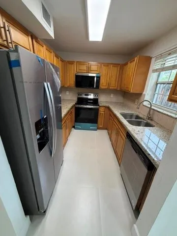 a kitchen with stainless steel appliances granite countertop a refrigerator and a stove