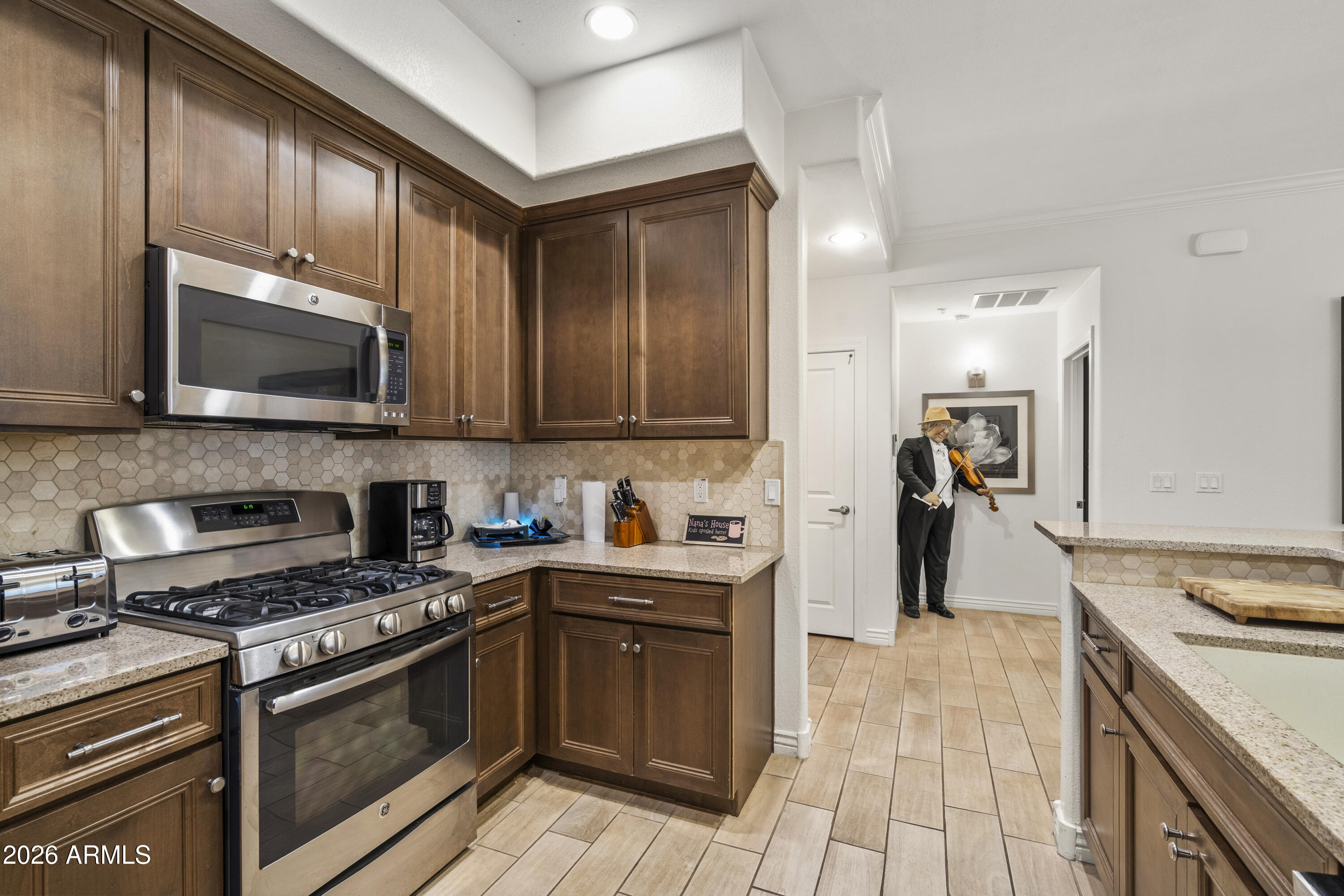 7601 East Indian Bend Road, Unit 1012 Scottsdale, AZ 85250 - Photo 11 of 27 a kitchen with stainless steel appliances granite countertop a stove top oven a sink dishwasher a refrigerator and cabinets with wooden floor