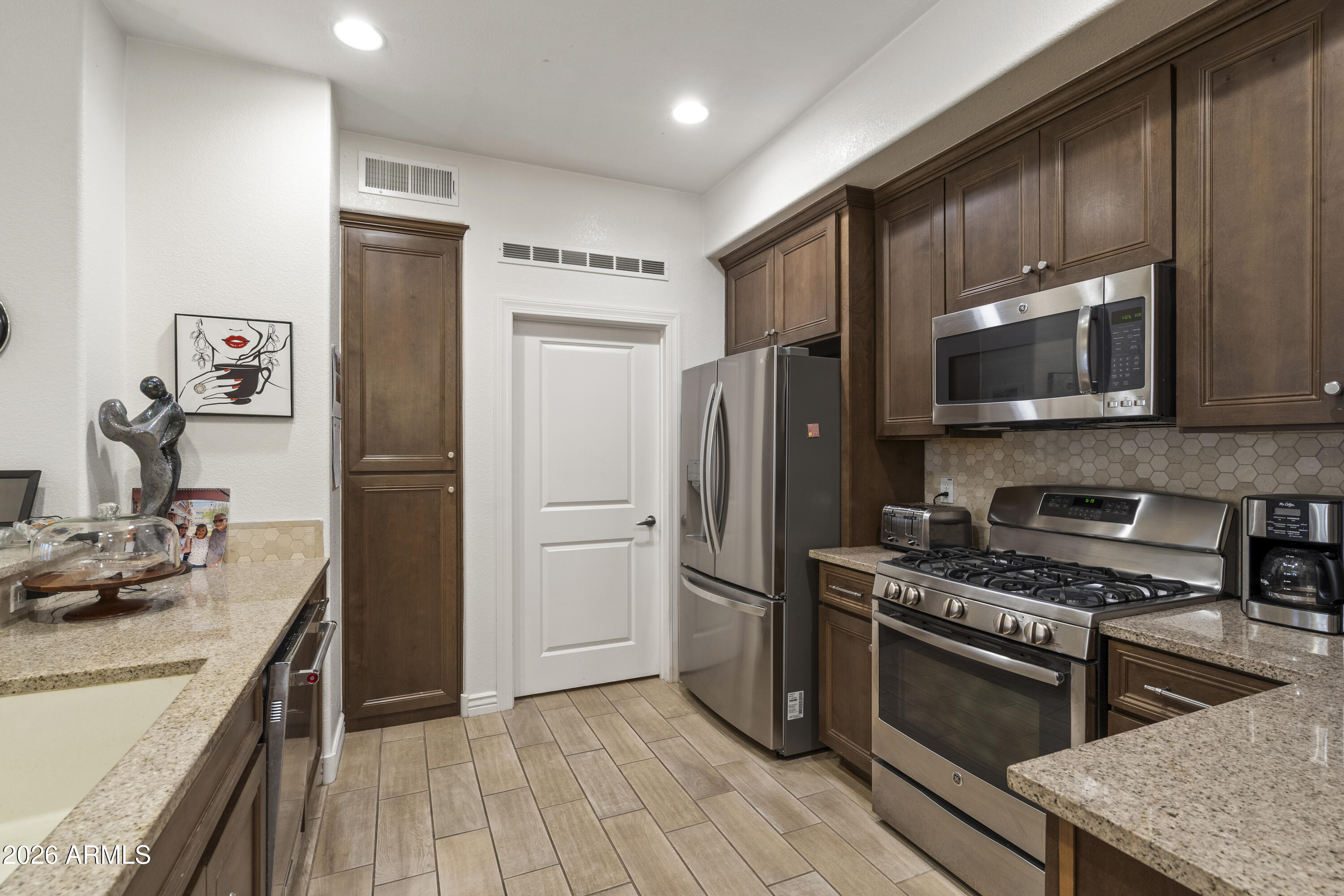 7601 East Indian Bend Road, Unit 1012 Scottsdale, AZ 85250 - Photo 10 of 27 a kitchen with stainless steel appliances a refrigerator stove and microwave