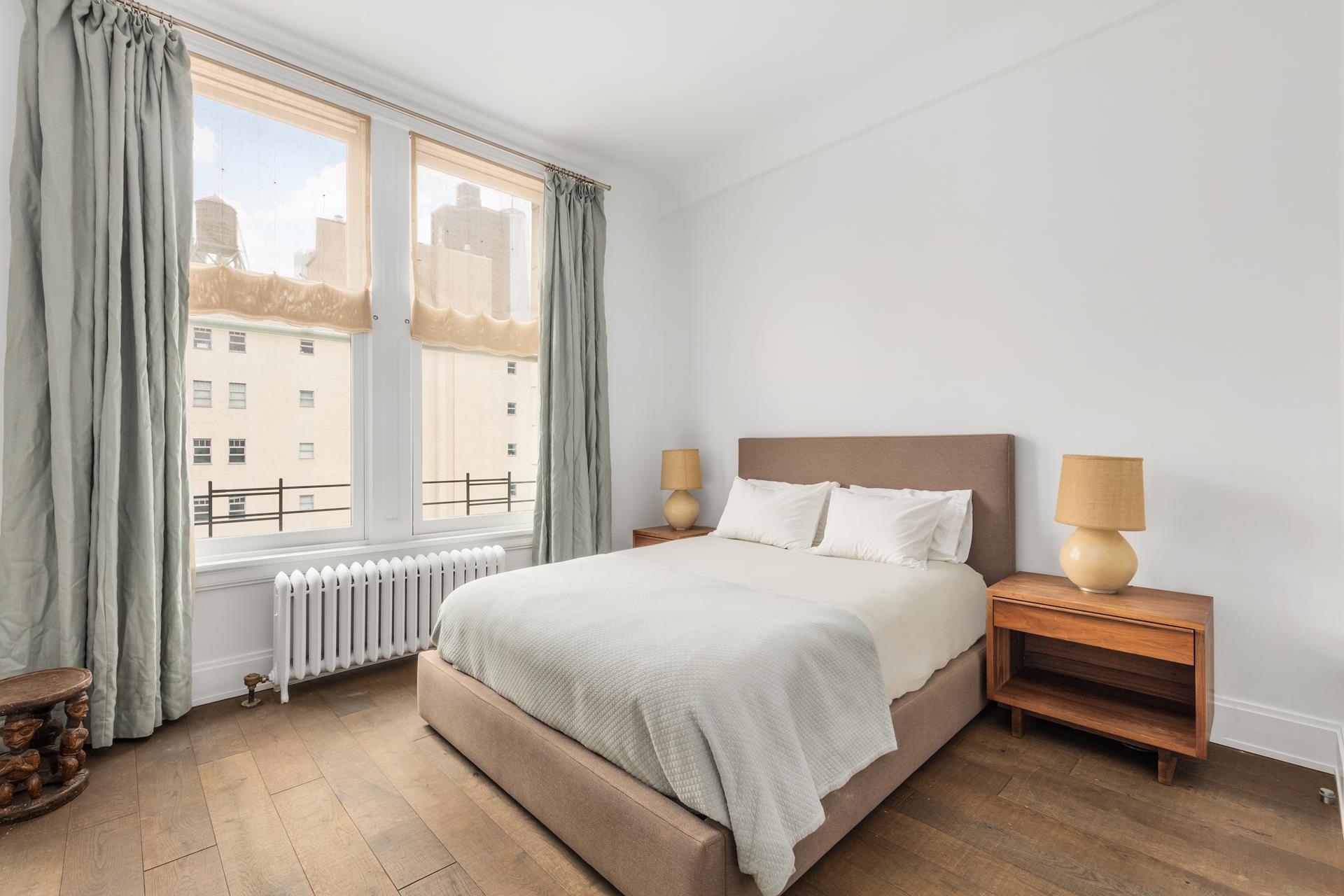 366 Broadway, Unit 10D Manhattan, NY 10013 - Photo 1 of 1 a bedroom with a bed table and a large window