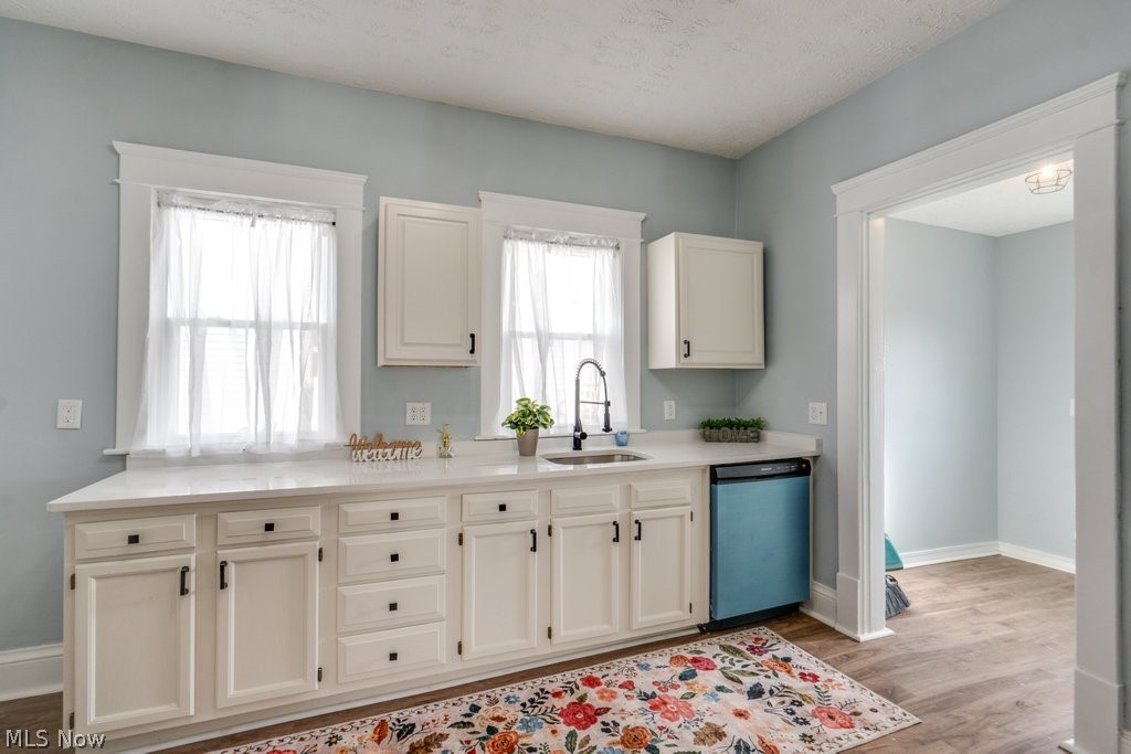 12 South 4th Street Rittman, OH 44270 - Photo 16 of 48 Kitchen featuring dishwashing machine, white cabinetry, light wood-type flooring, light stone counters, and a textured ceiling