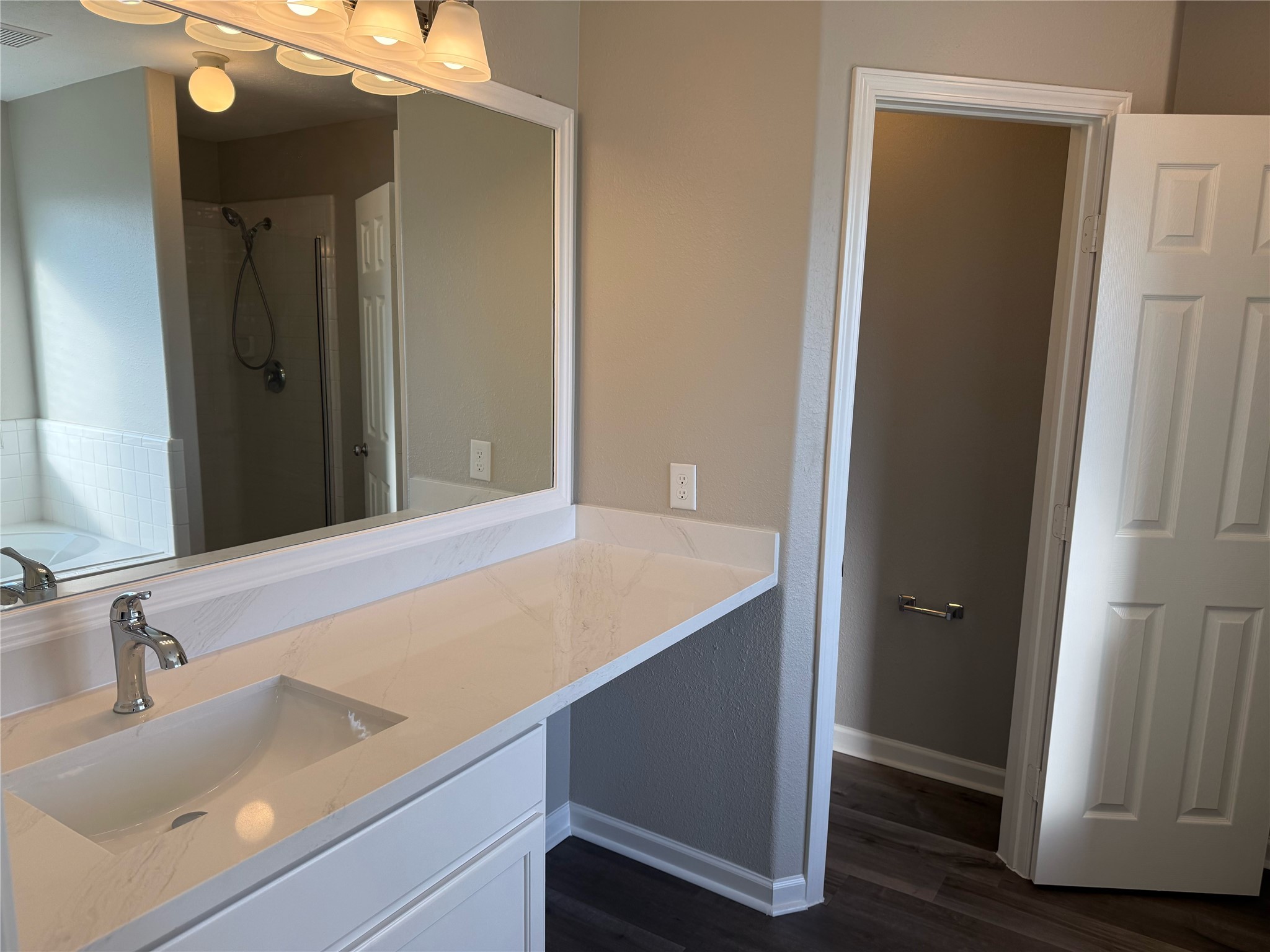 13210 Barton Meadow Lane Rosharon, TX 77583 - Photo 13 of 21 This bathroom features a large mirror, modern vanity with a marble countertop, and sleek fixtures. It includes a separate shower area and a private toilet space, offering a clean and contemporary design.