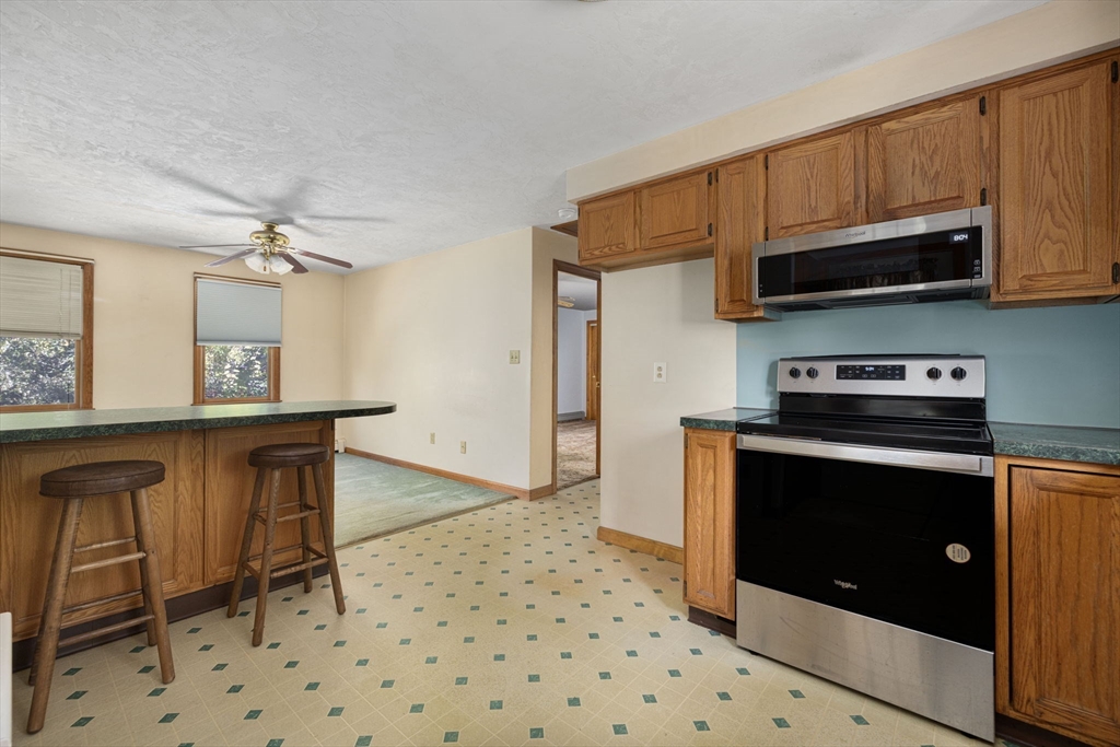 40 Union Street Blackstone, MA 01504 - Photo 33 of 40 a kitchen with stainless steel appliances granite countertop a stove a sink and a microwave