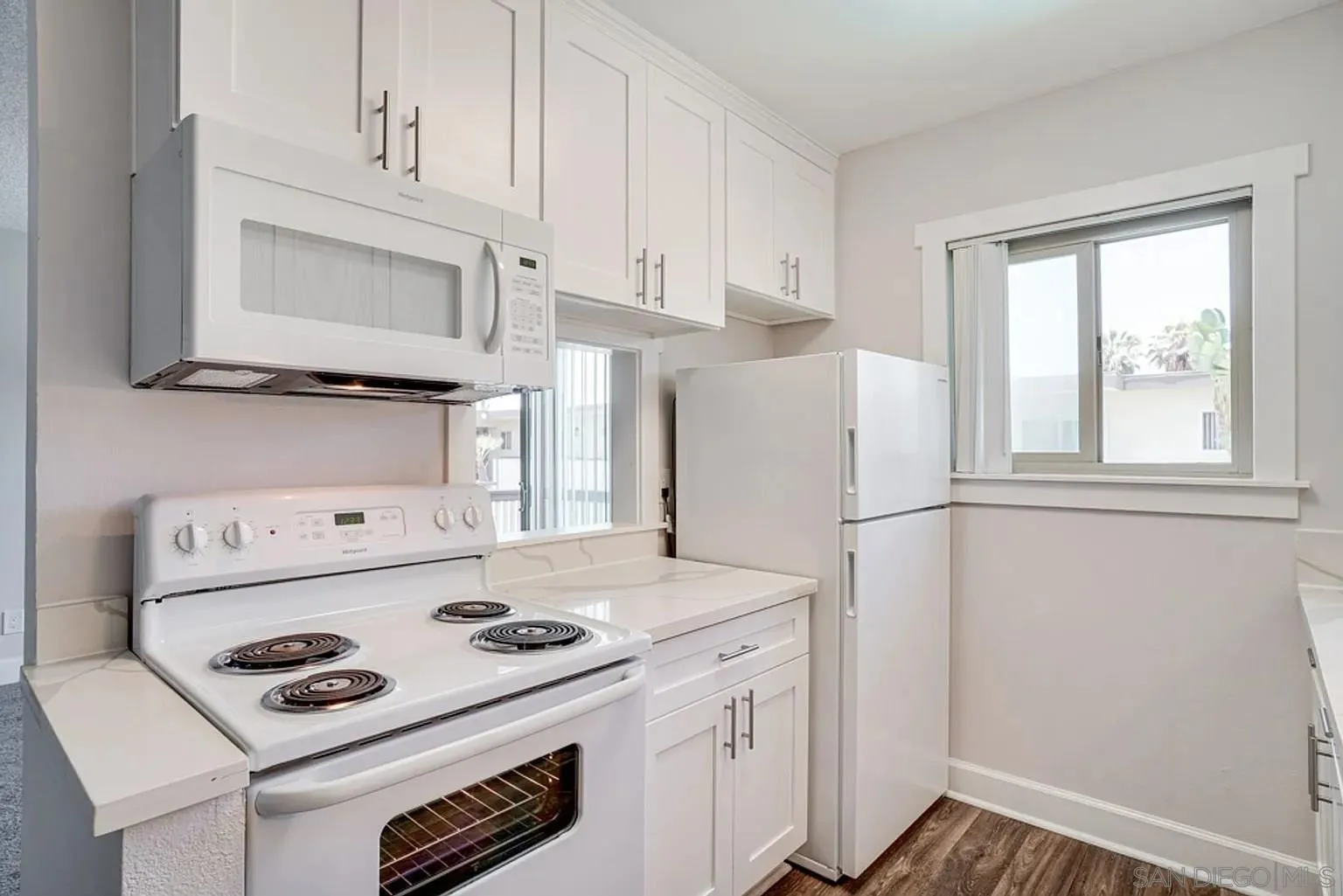 600 F Street Chula Vista, CA 91910 - Photo 8 of 12 a kitchen with a stove a refrigerator and a white cabinets
