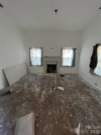 a view of an empty room with a window and fireplace