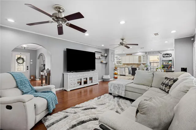 a living room with furniture kitchen view and a flat screen tv