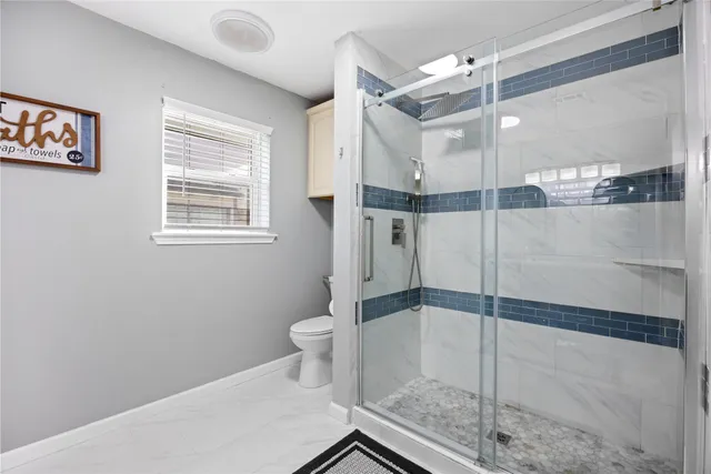 a bathroom with a shower toilet and sink