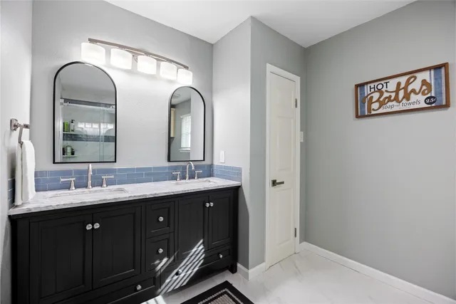 a bathroom with a double vanity sink and a mirror