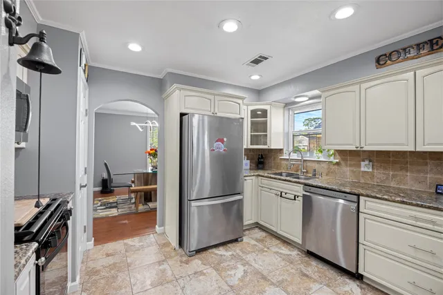 a kitchen with granite countertop a refrigerator and a sink