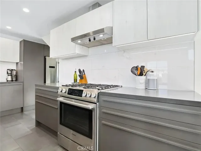 a kitchen with a stove and white cabinets