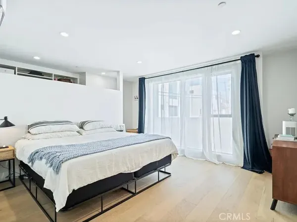 a spacious bedroom with a bed and a window