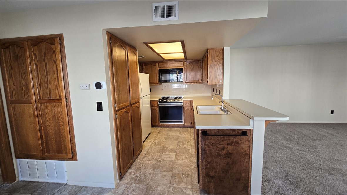1190 Ramar Road, Unit 27 Bullhead City, AZ 86442 - Photo 9 of 15 a kitchen with granite countertop stainless steel appliances a refrigerator and a stove top oven
