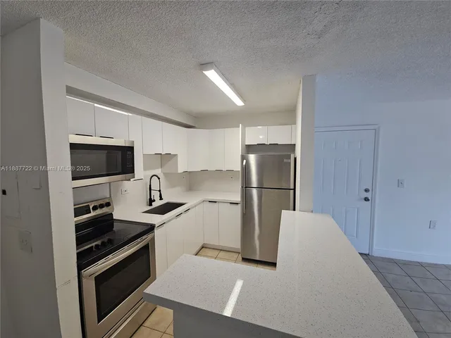 a kitchen with stainless steel appliances a refrigerator stove and microwave