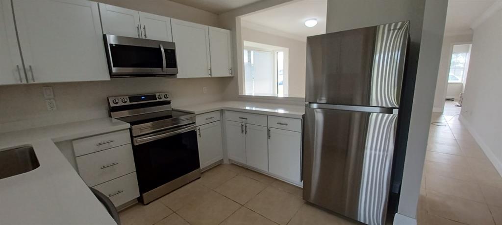 519 Southwest Sara Boulevard Port St. Lucie, FL 34953 - Photo 12 of 18 a kitchen with a refrigerator stove and microwave