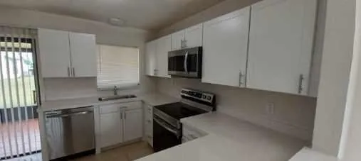 a kitchen with stainless steel appliances a sink stove and microwave