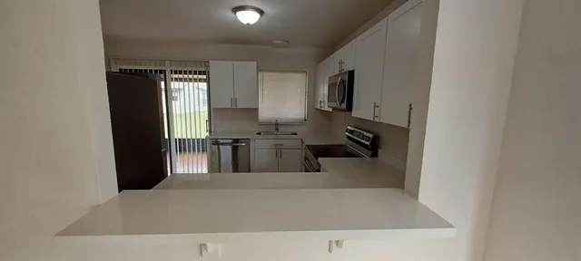 a kitchen with a refrigerator and a sink