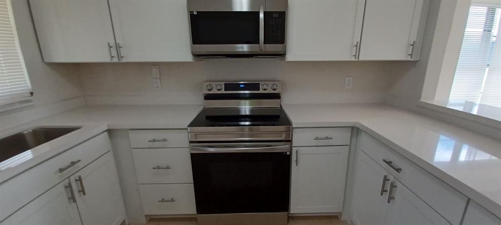 519 Southwest Sara Boulevard Port St. Lucie, FL 34953 - Photo 8 of 18 a kitchen with cabinets appliances and a window