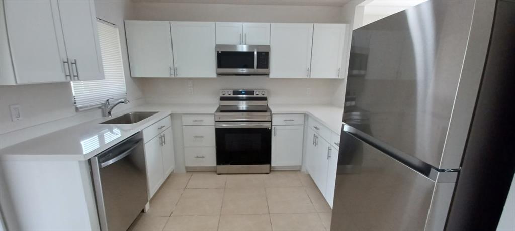 519 Southwest Sara Boulevard Port St. Lucie, FL 34953 - Photo 10 of 18 a kitchen with stainless steel appliances granite countertop a refrigerator stove and sink