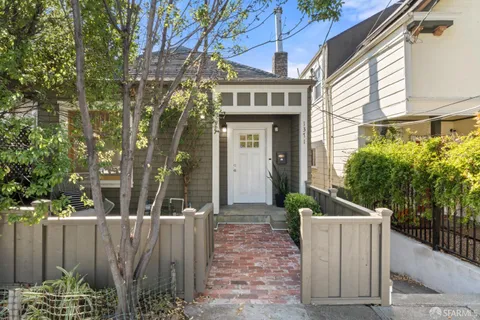 a view of a house with a wooden fence