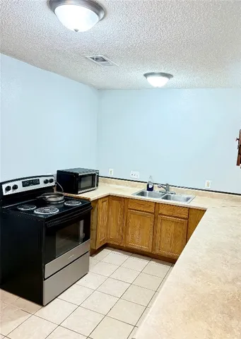 a kitchen with granite countertop a stove and a sink
