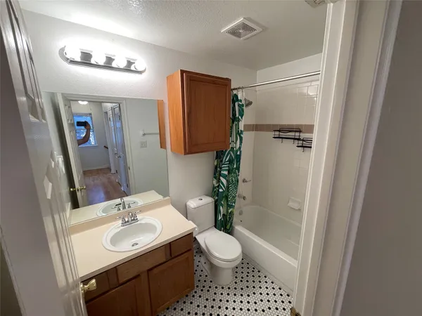a bathroom with a black white checkered floor and a sink