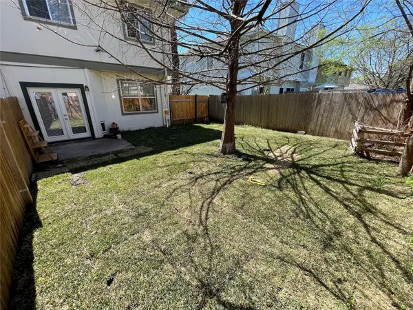 a view of a yard with a house and a large tree