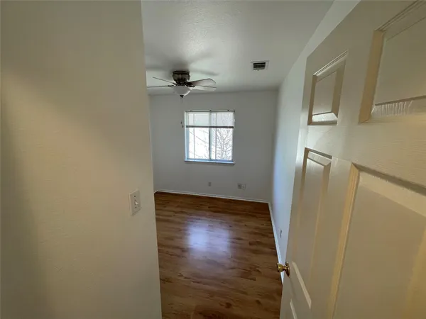 a view of empty room with a ceiling fan and wooden floor