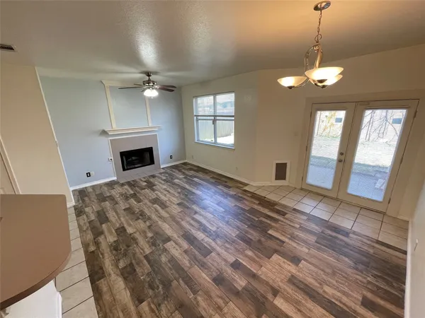 a view of an empty room with a fireplace and a window
