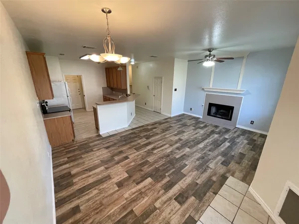 a view of a livingroom with a fireplace a chandelier wooden floor and chandelier