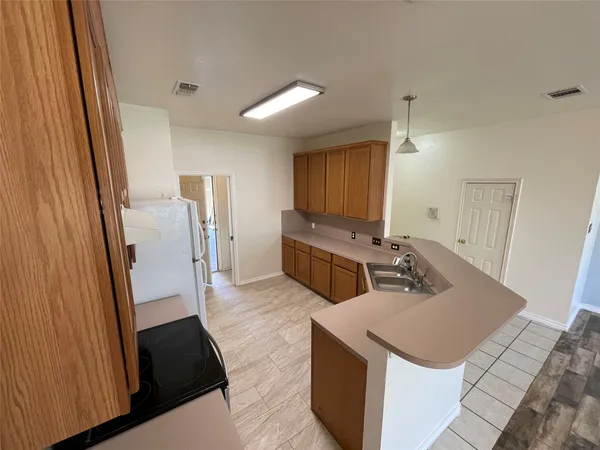 a kitchen with sink refrigerator and stove
