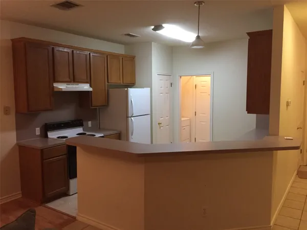 a kitchen with cabinets a refrigerator and a stove
