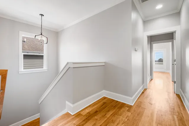 a view of an empty room with a window and a kitchen