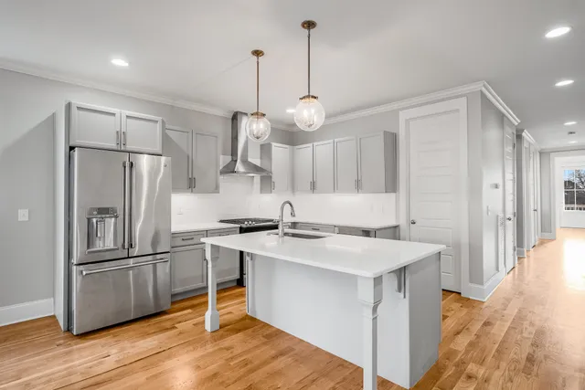 a kitchen with kitchen island a sink stainless steel appliances and cabinets