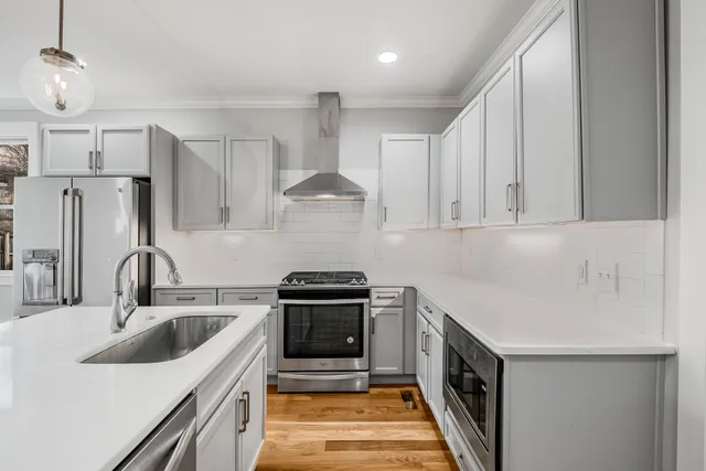 a kitchen with kitchen island a sink stainless steel appliances and cabinets