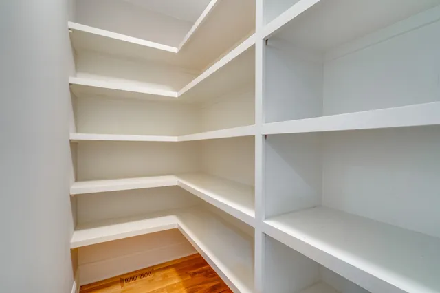 a view of a livingroom with wooden floor and a ceiling fan