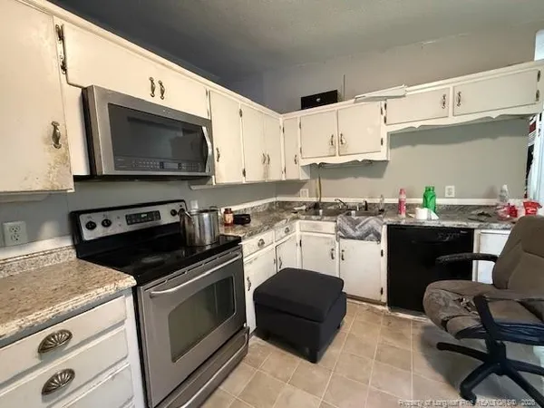 a kitchen with a stove a sink and a microwave
