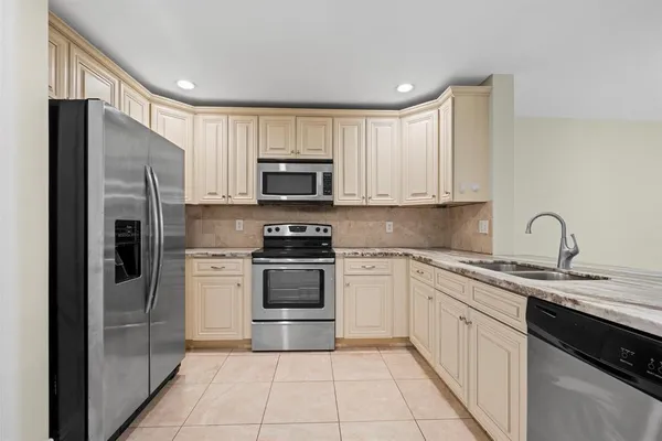 a kitchen with stainless steel appliances granite countertop a refrigerator sink and cabinets