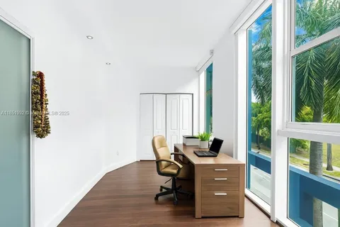 a view of a workspace with furniture and a window
