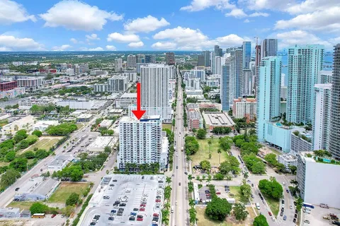 a front view of a house with lots of plants and seating