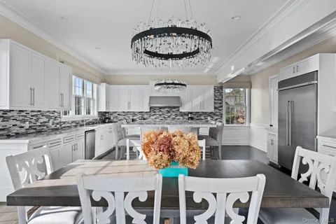 a kitchen with stainless steel appliances kitchen island granite countertop a dining table chairs sink and granite counter tops
