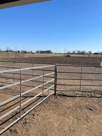 a view of a yard with wooden fence