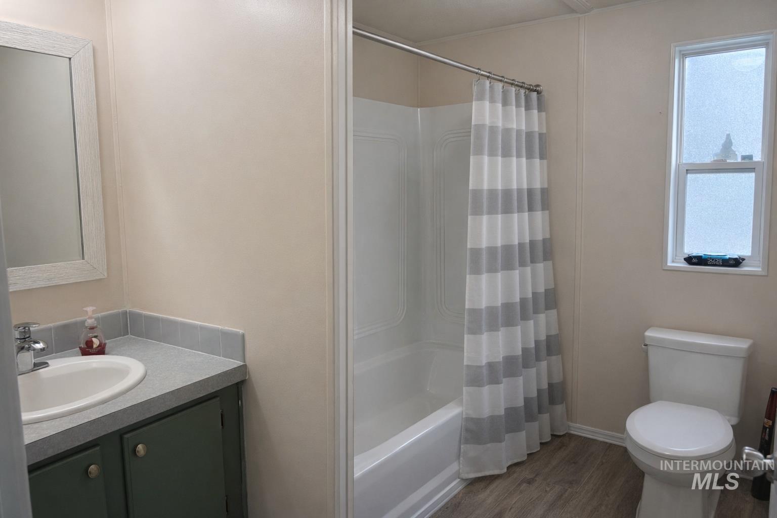 700 East Fairview Avenue, Unit 195 Meridian, ID 83642 - Photo 14 of 19 Full bath with vanity, shower / bath combo with shower curtain, and dark wood finished floors