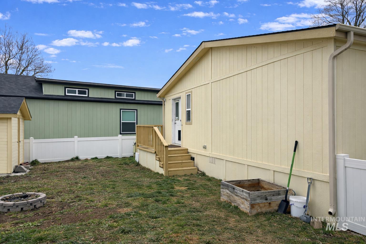 700 East Fairview Avenue, Unit 195 Meridian, ID 83642 - Photo 17 of 19 Back of property featuring roof with shingles and a fire pit