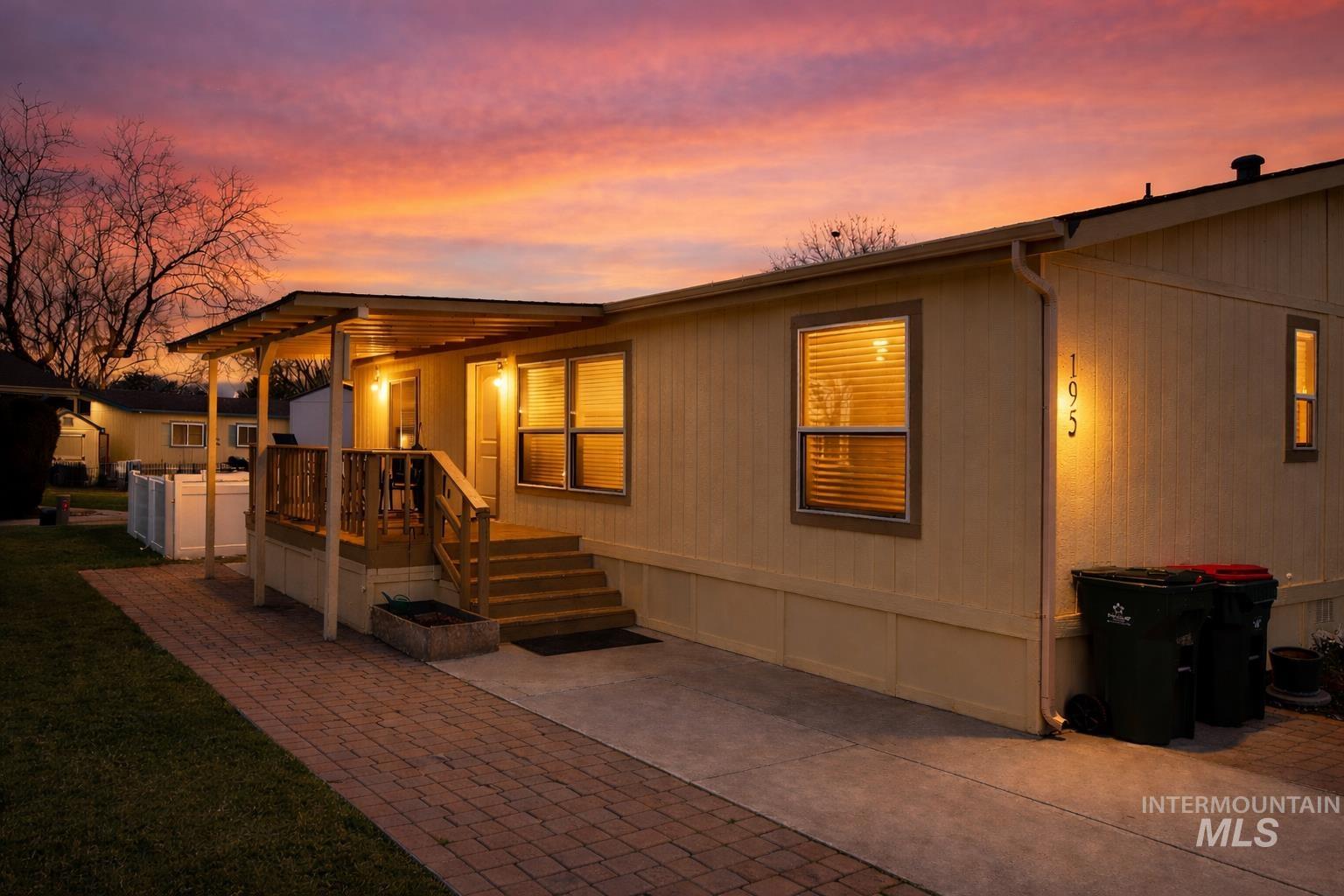 700 East Fairview Avenue, Unit 195 Meridian, ID 83642 - Photo 2 of 19 Back of house at dusk featuring a deck and a yard