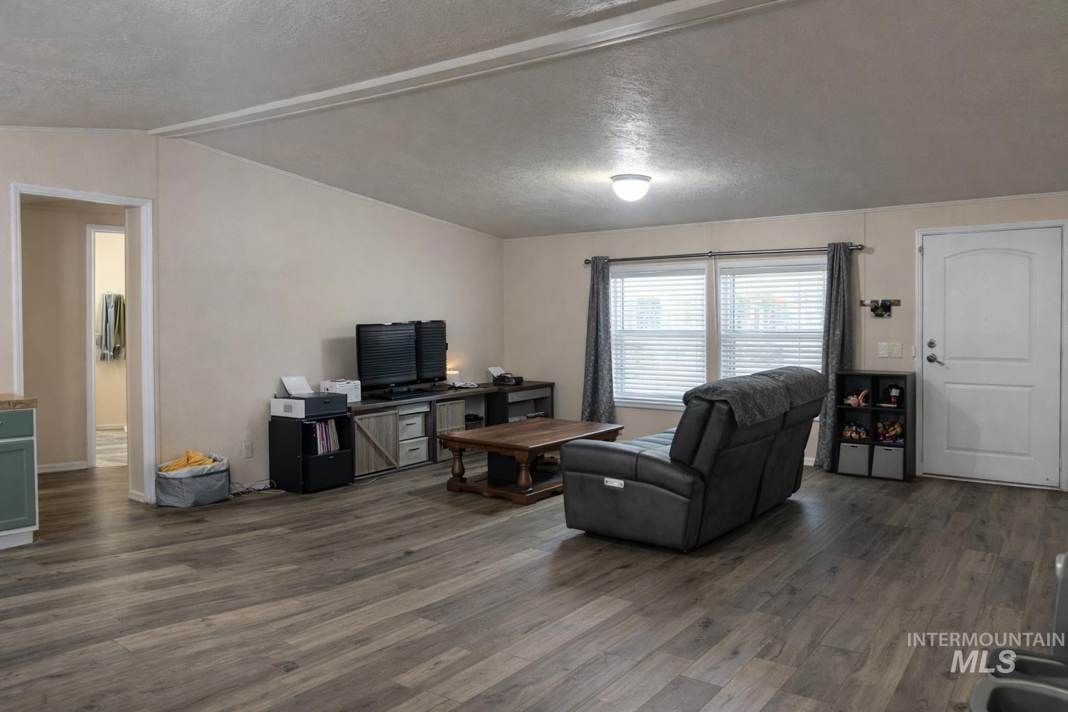 700 East Fairview Avenue, Unit 195 Meridian, ID 83642 - Photo 5 of 19 Living room featuring a textured ceiling, dark wood-style floors, and vaulted ceiling